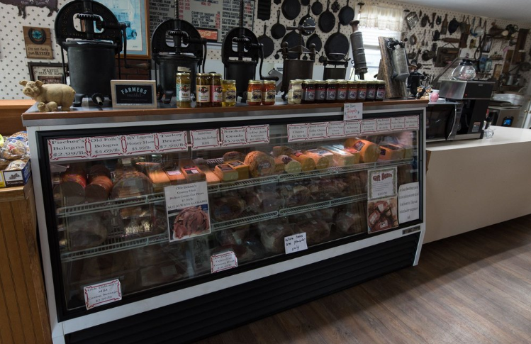 Inside Olde Delaney's Country Ham Store — deli case with country hams, bologna, and Kentucky pantry goods